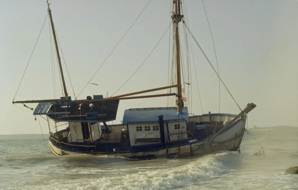 Strandet træbåd, kystscene i Danmark.